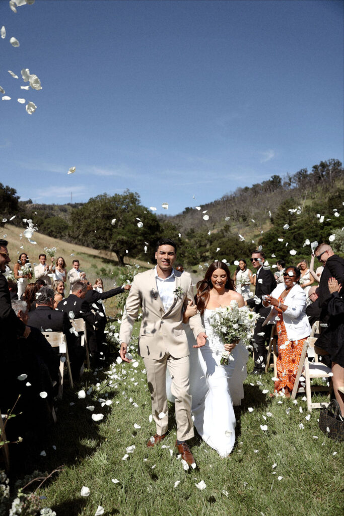 Bride and groom wedding ceremony exit with flower petals 