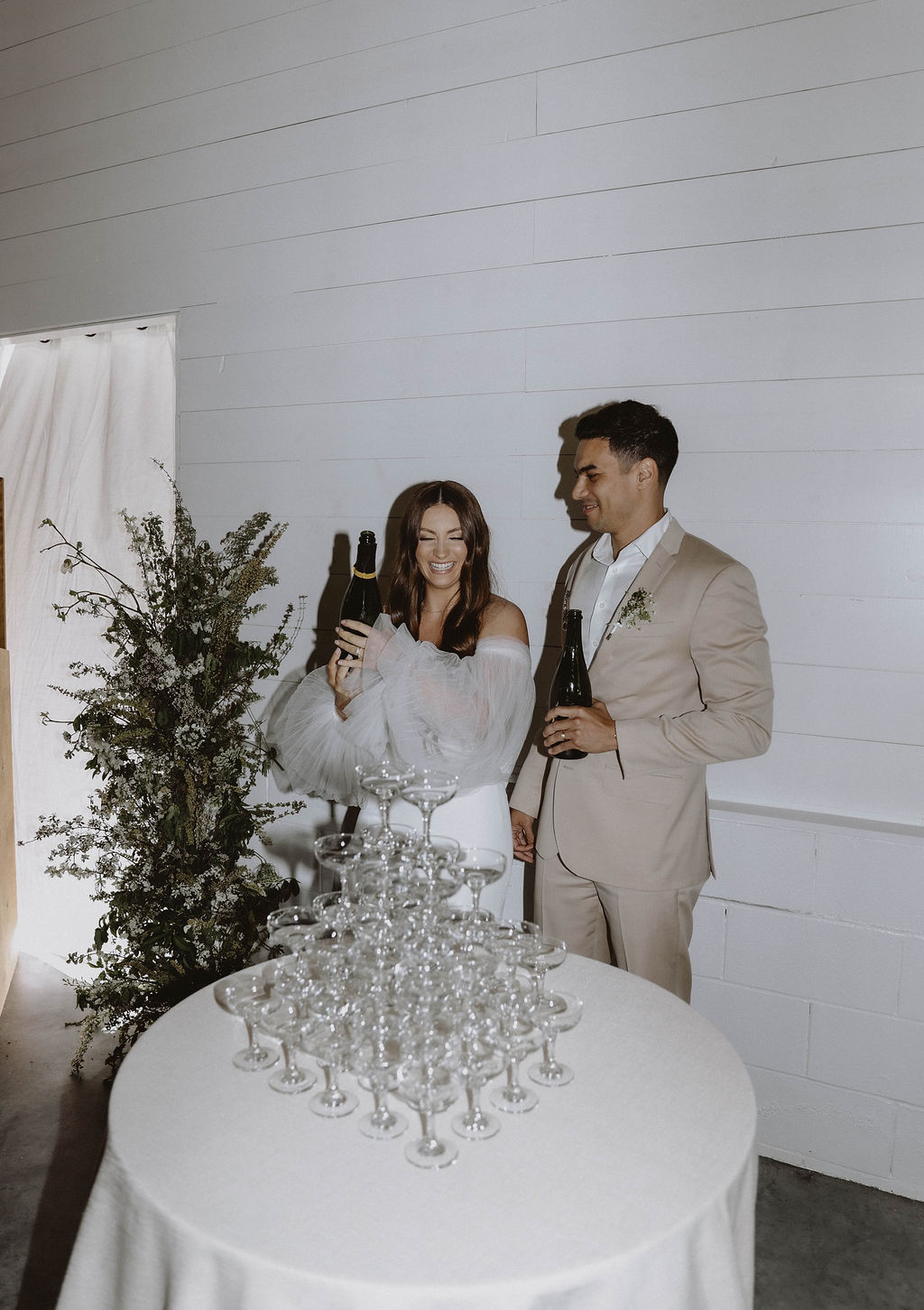 couple doing a champagne tower - wedding day timeline
